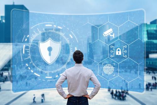 Man viewing digital security interface with shield, camera, lock, and fingerprint icons, set against an urban backdrop.