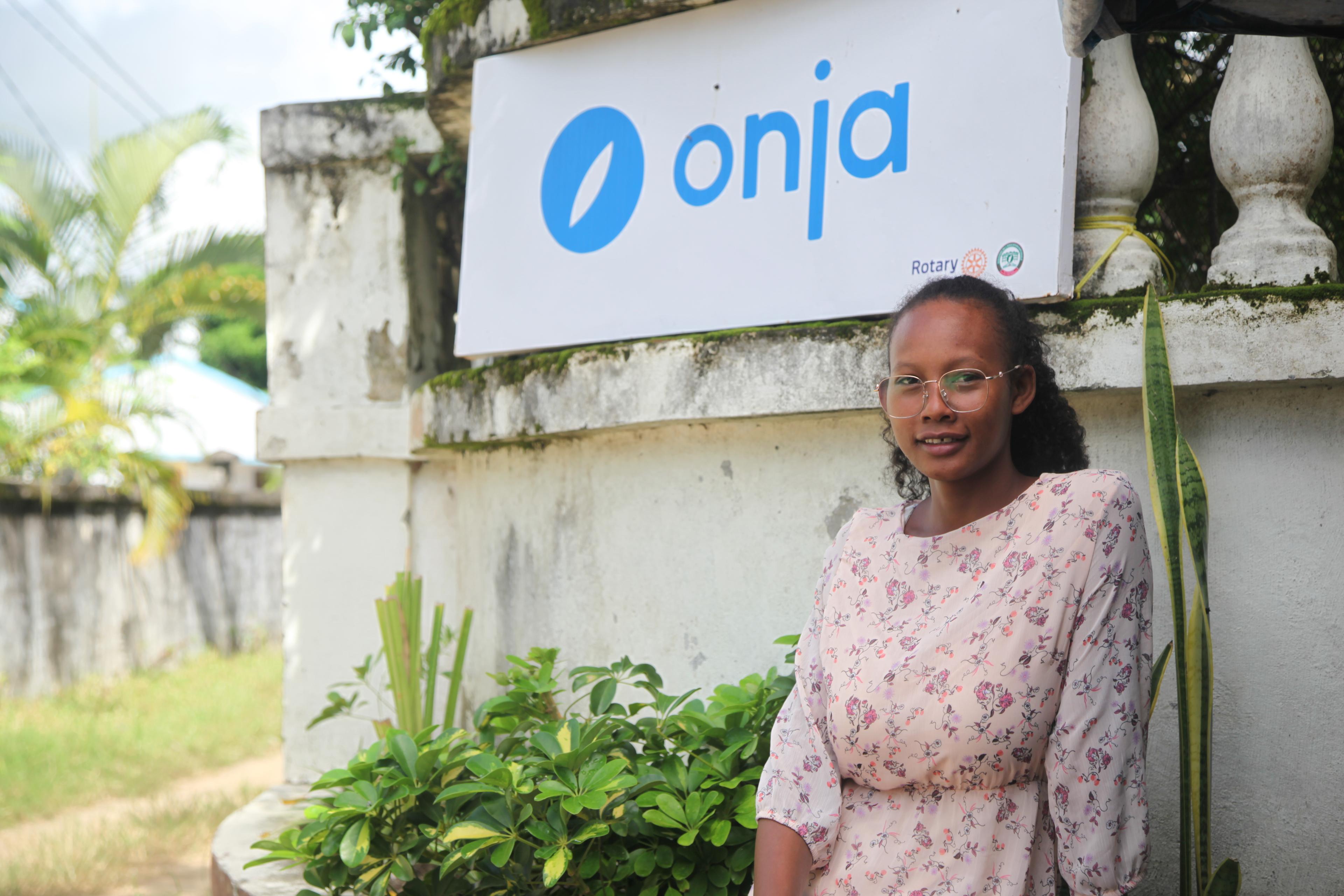 Clopedia standing in front of the Onja sign